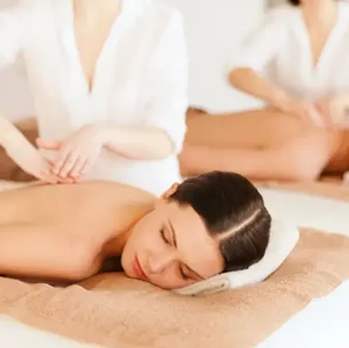 Outdoor wellness event featuring multiple massage stations beneath white canopy tents